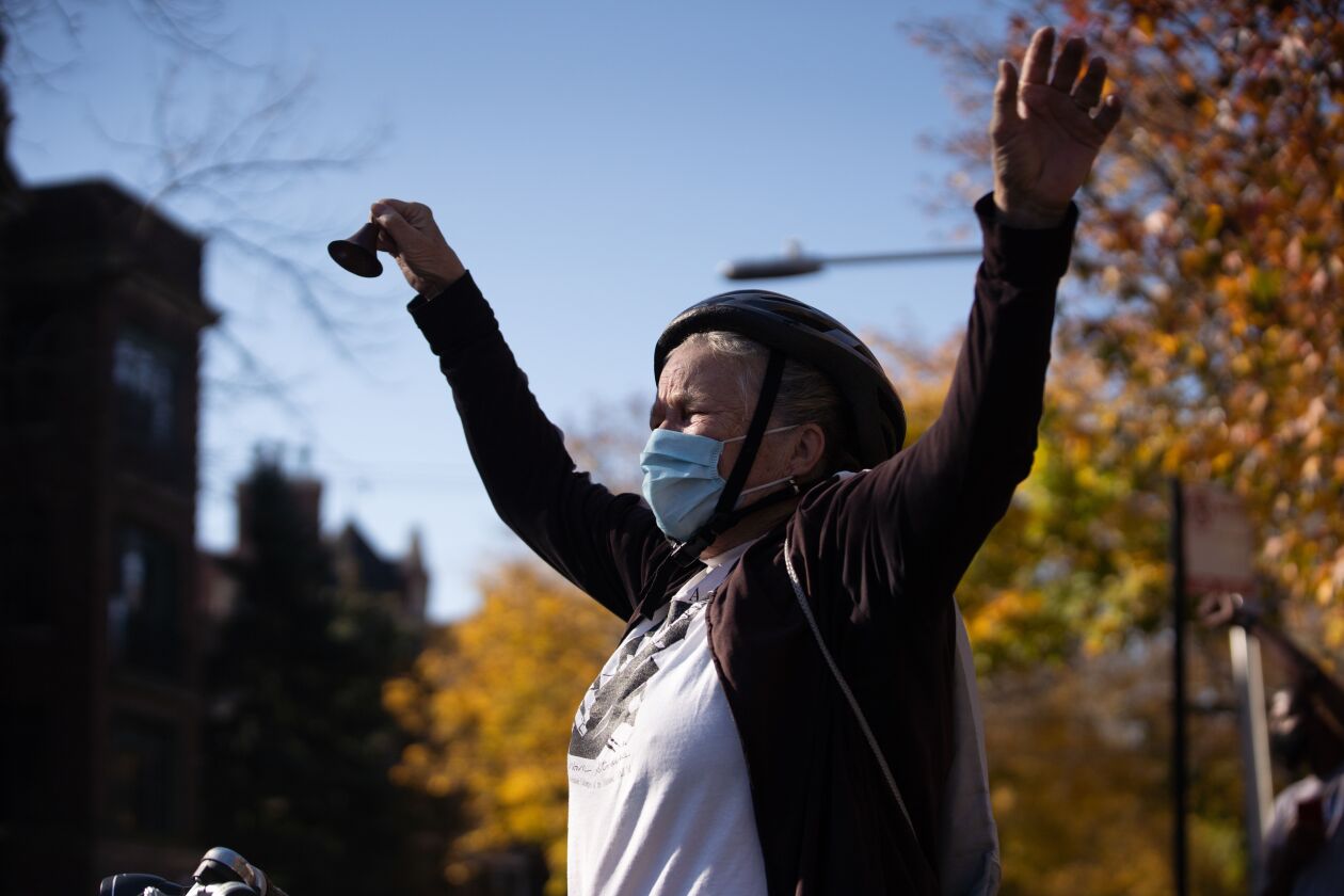 Katy Hogan rings a bell while cheering for President-elect Joe Biden on North Sheridan Road in the Rogers Park neighborhood, hours after his victory was announced Saturday.